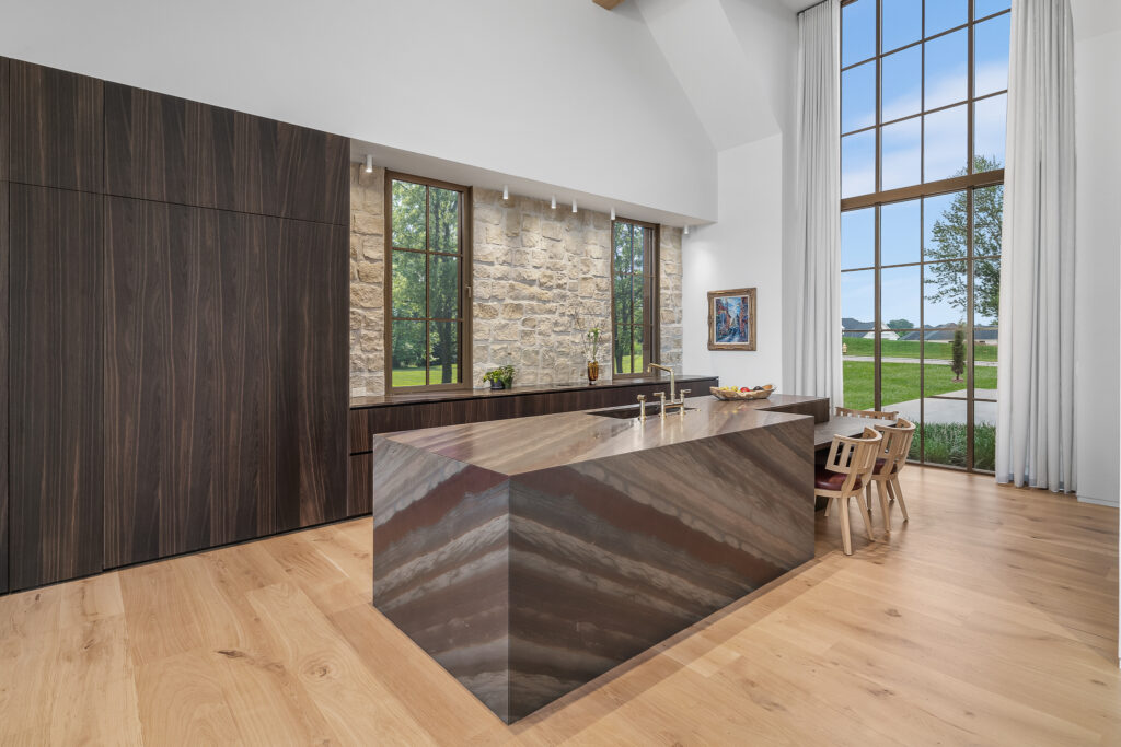 Modern Farmhouse kitchen with white-stone walls, modern cabinetry, and a monolithic kitchen island 