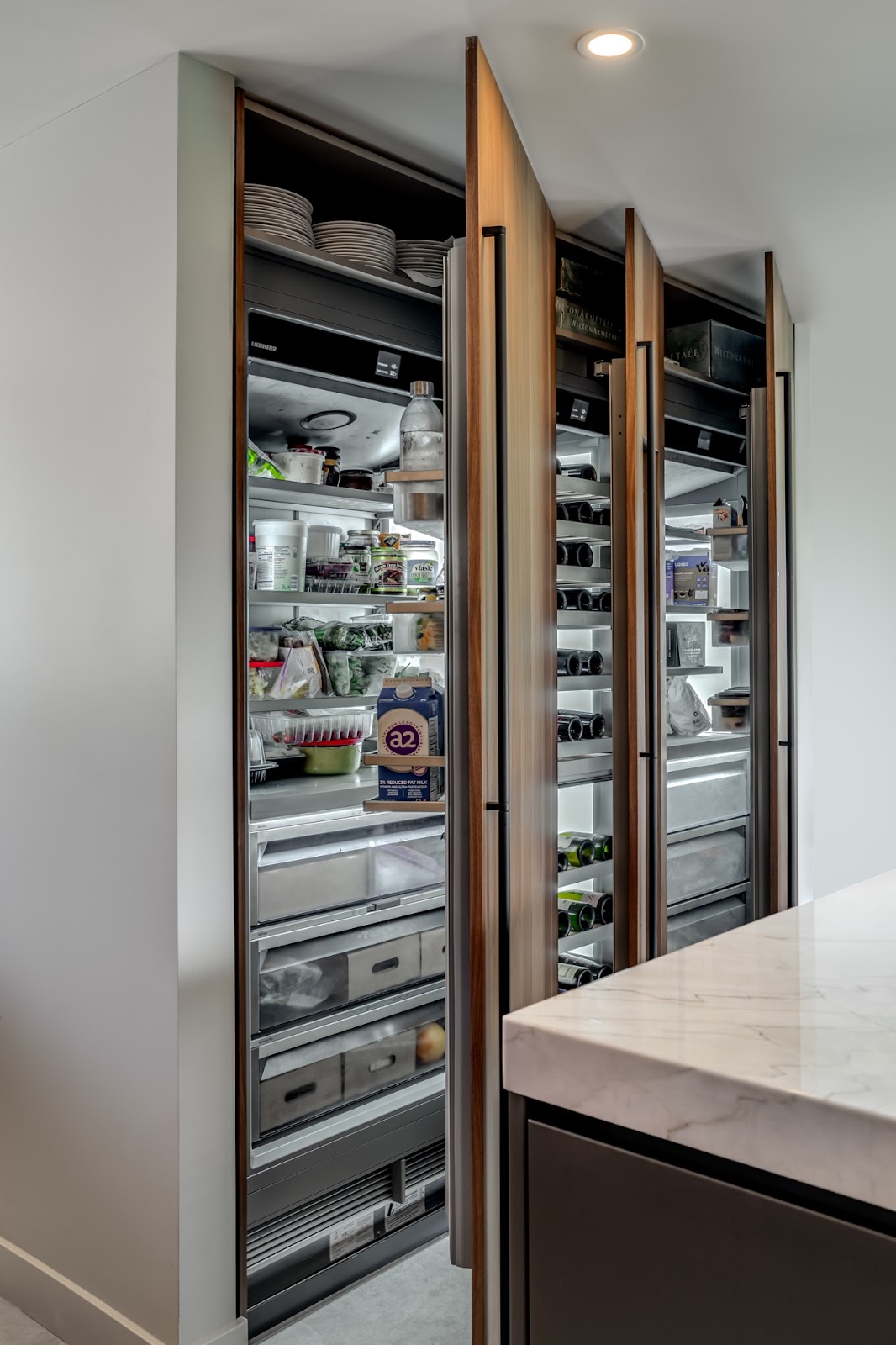 Kitchen storage is positioned near the point of entry to ensure that cold and room temperature ingredients are easy to access
